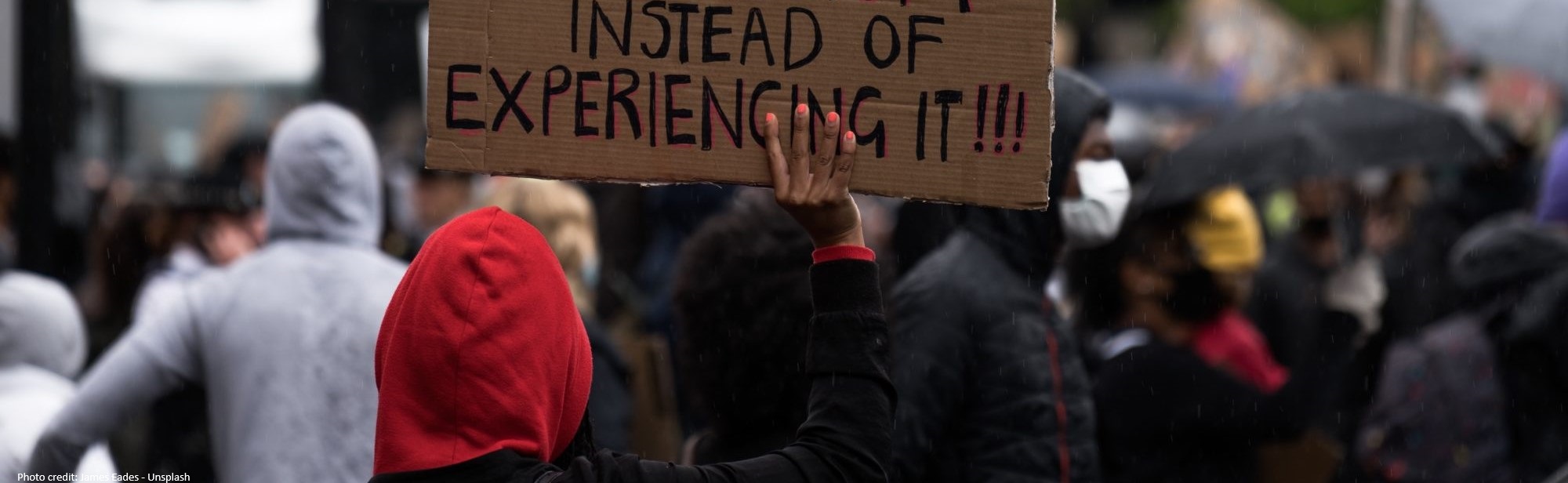 the back of a person holding a sign in protest
